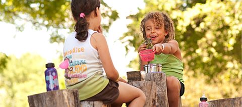 two children playing on stumps