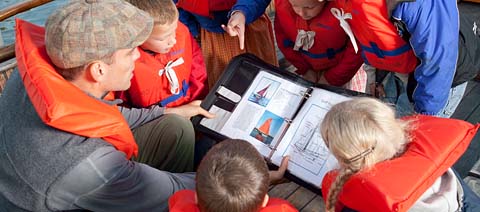 teacher showing children pictures of boats