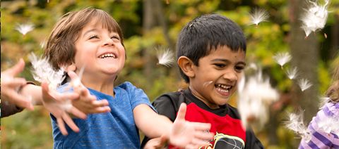 children catching falling leaves